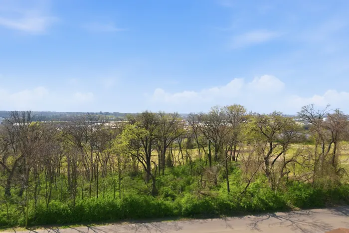 Wide aerial of golf course, river, and skyline